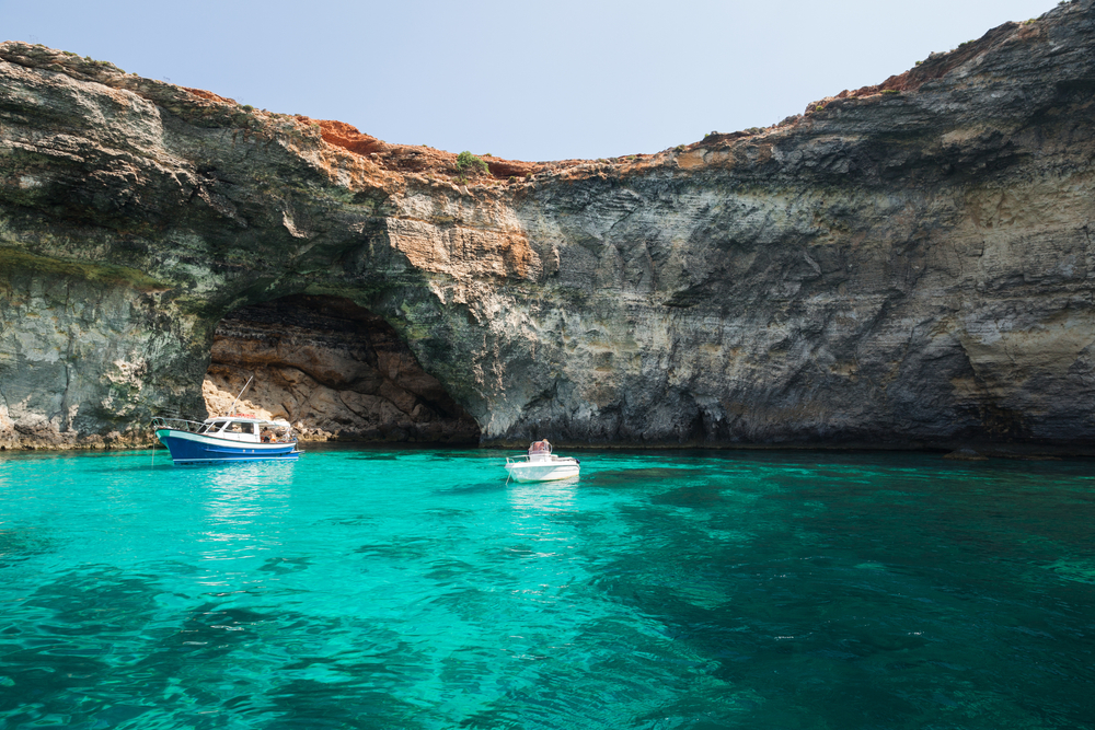 Unforgettable Adventure Destinations for Solo Seniors - Pleasure boats at Blue Lagoon of Comino, Malta
